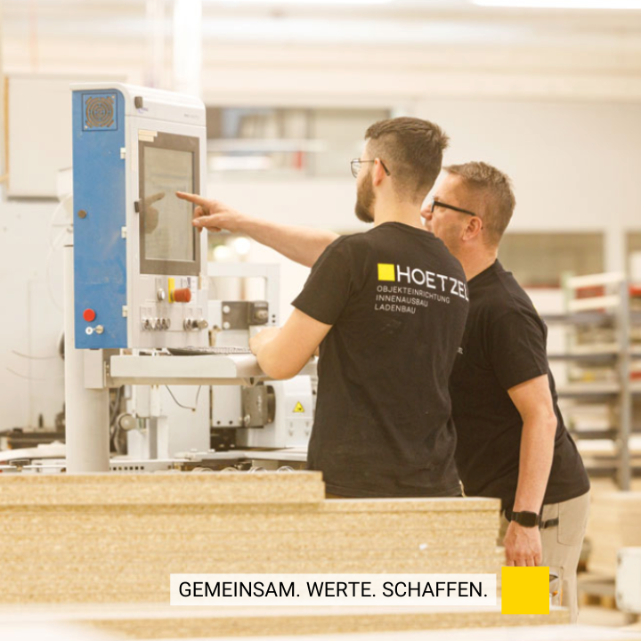 Zwei Hoetzel Mitarbeiter, einer zeigt auf einen Bildschirm